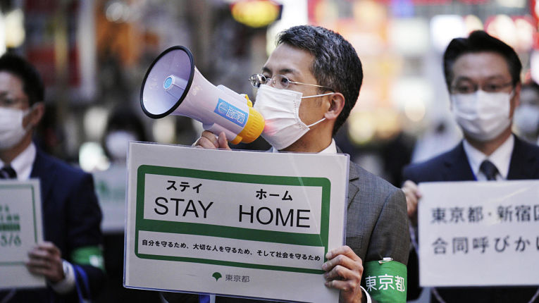 Agentes do governo metropolitano de Tokyo fazendo campanha para as pessoas manterem-se em casa