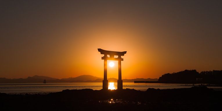 Sol atrás do torri do templo de Nagao