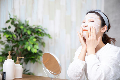 Mulher aplicando máscara facial