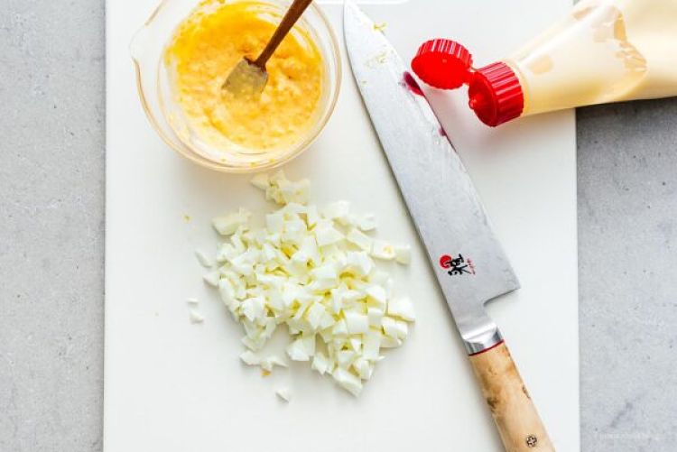 Misturando a pasta de gema com maionese com a clara cozida picada do tamago sando