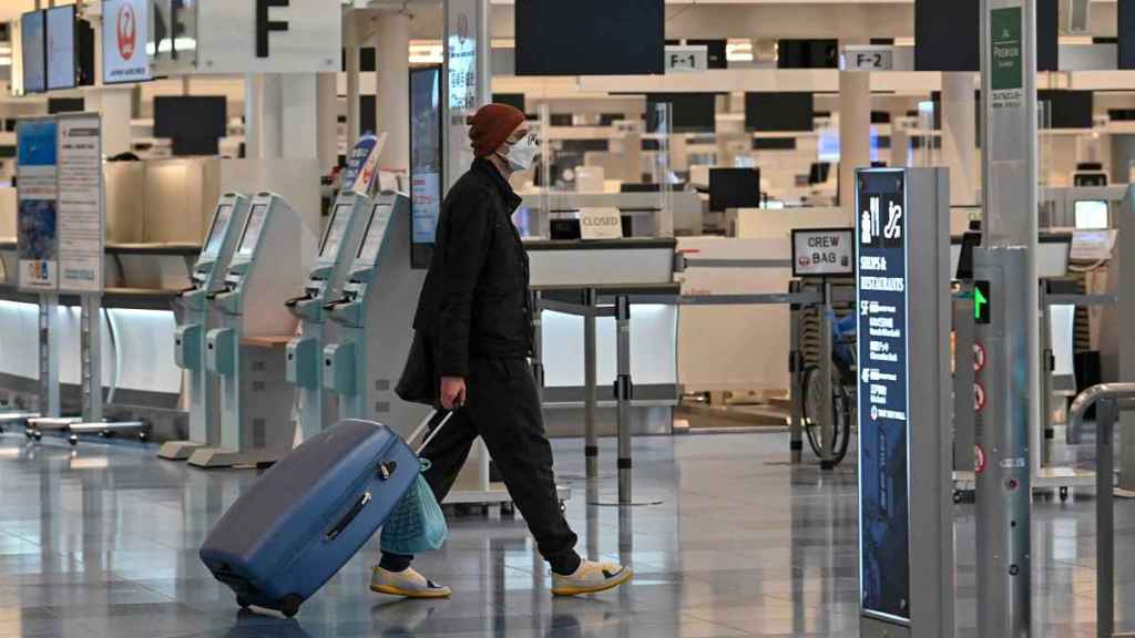 Homem faz check-in no aeroporto de Haneda em dezembro de 2021.