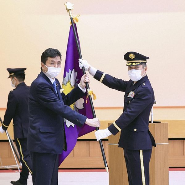 Ministro da Defesa Kishi Nobou (esquerda) entrega estandarte com bandeira da nova unidade de defesa cibernética ao major-general, Kimura Akitsugu (direita)