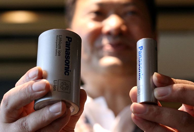 CEO da Panasonic, Kazuo Tadanobu, segura nova bateria 4680 (esquerda) e 2170 (direita). Foto por Tim Kelly, Reuters/File Photo