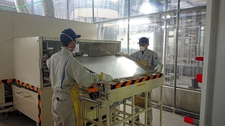 Profissionais operam máquina de reciclagem de painéis fotovoltaicos da NPC Inc.