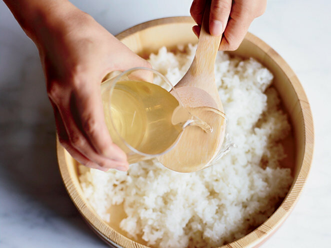 Adicionando vinagre no arroz de sushi