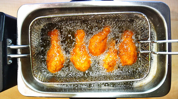 Fritando o frango em óleo quente