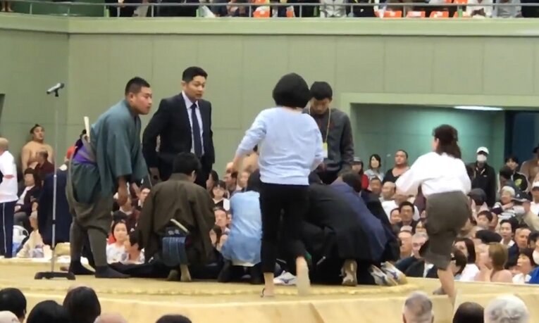 Profissionais de saúde são retiradas do dohyō enquanto salvam a vida do prefeito. Após o incidente, os organizadores do evento "purificaram" o local com uma quantidade significativa de sal