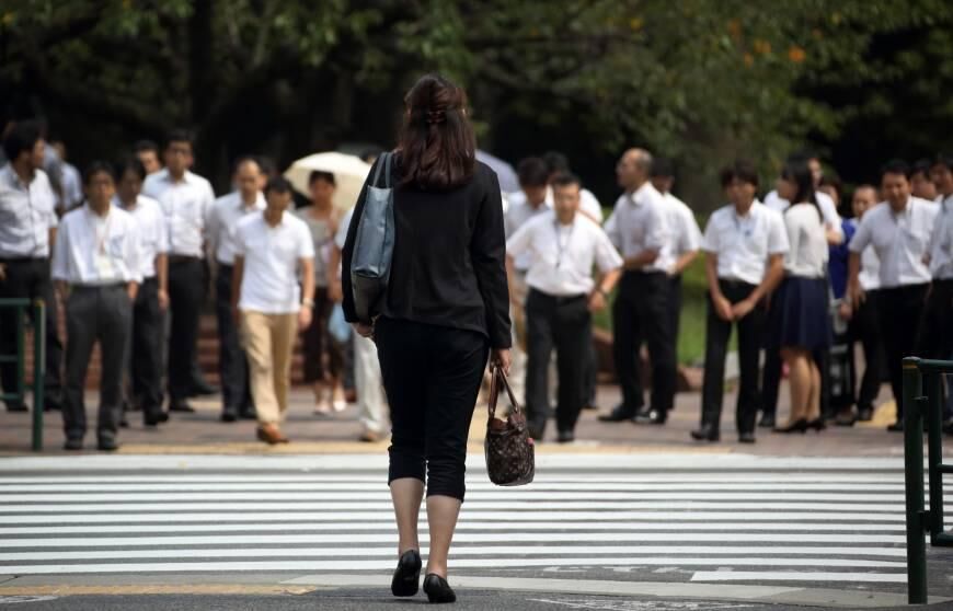 Mulher vestida com roupa tradicional de salarywomans no Japão cruzando a rua mostra disparidade de gênero de forma conceitual