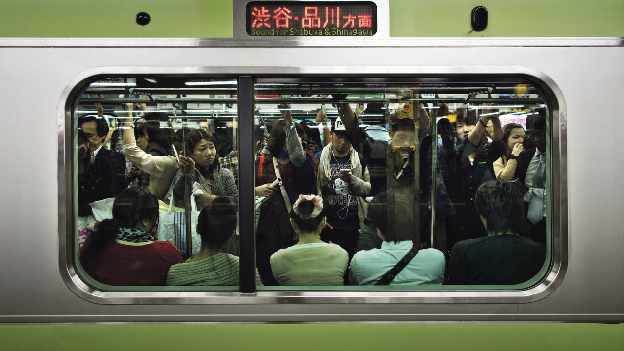 Trabalhadores no Japão dentro de vagão do metrô