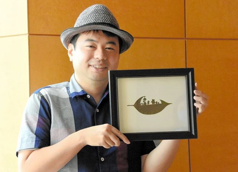 Lito Leaf Art com uma de suas folhas com arte feita com lâmina cirurgica