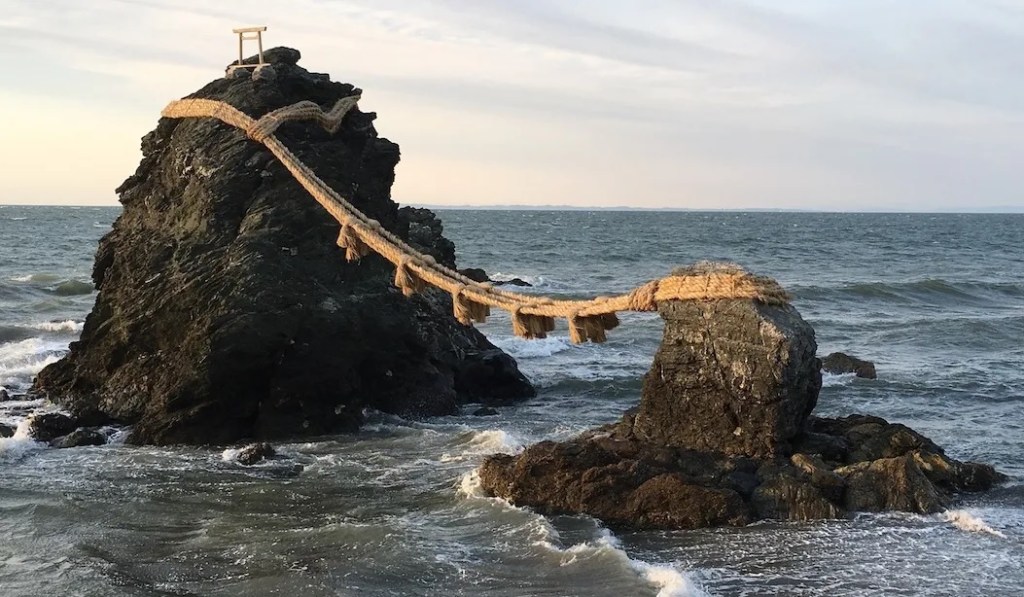 Meoto Iwa ("夫婦岩", rochas casadas) do santuário Futami Okitama Jinja. As rochas representam o masculino e o feminino, bem como os kami criadores do Japão Izanagi e Izanami, e em última análise, Yin-Yang