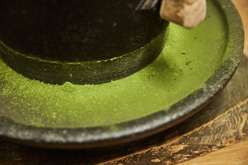 Trituração de folhas de matcha secas a mão para cerimônias leva a um tipo especial e refinado