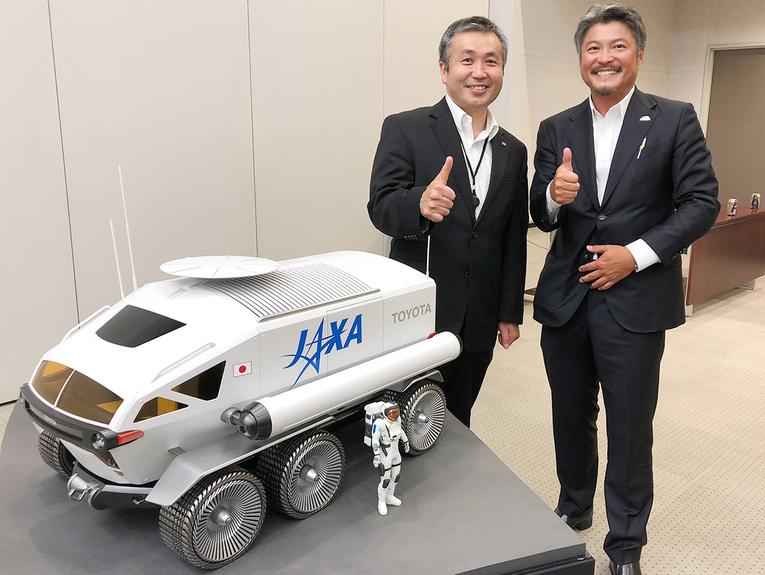 Koichi Wakata, vice-presidente da JAXA (esquerda), e Takao Sato, líder do projeto da Toyota "Lunar Exploration Mobility Works" (direita) com o Toyota Lunar Cruiser conceitual em miniatura