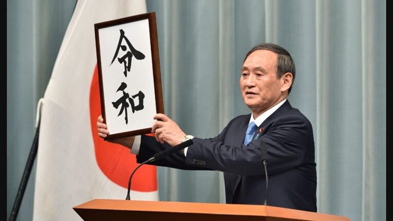 Ex-primeiro ministro Yoshihide Suga apresenta o nome da nova era do Japão após a entronização do Imperador Naruhito em 2019